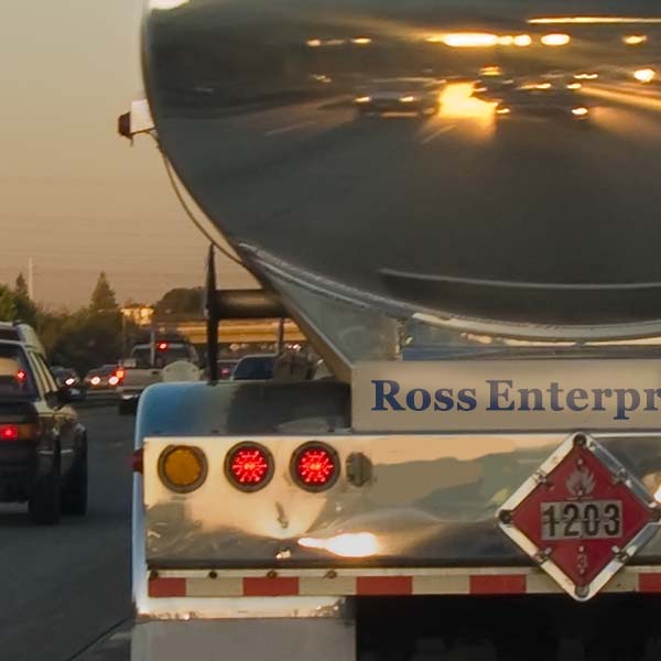 Rear of a tanker truck on a street, with flammable sign and the Ross Enterprise name on the back.